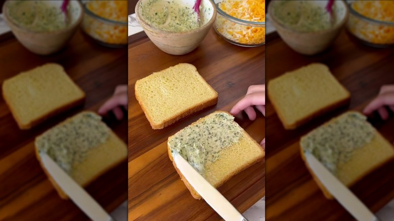 Spreading garlic and herb butter onto slices of bread