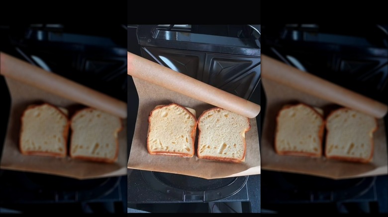 Cheese sandwiches in panini press with parchment paper