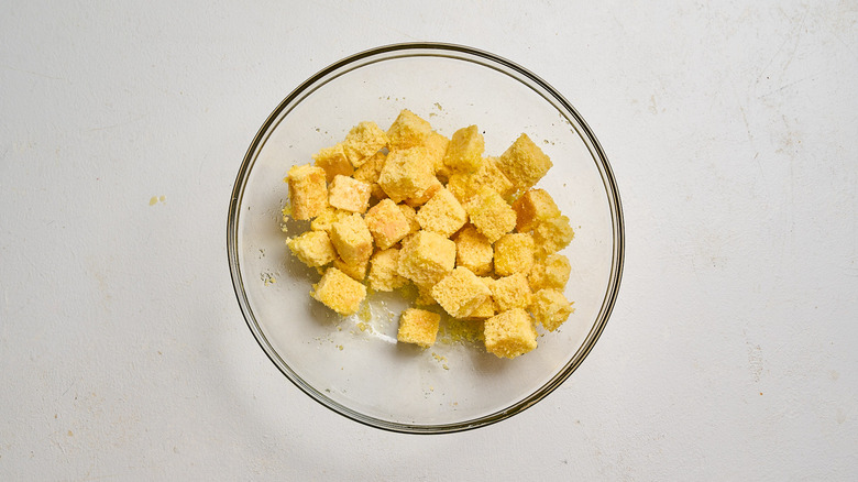cornbread tossed with oil in a bowl