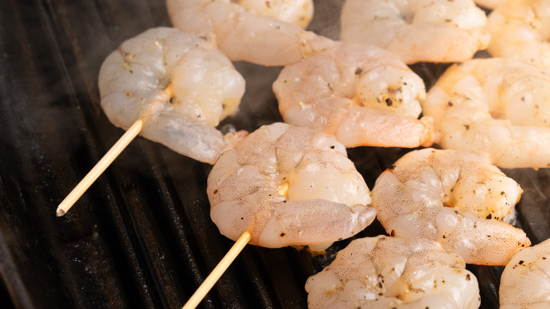 close up of shrimp skewers cooking in griddle pan