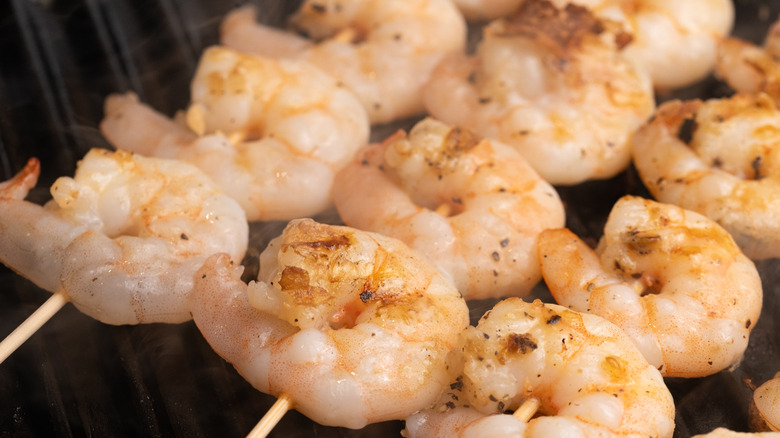 close up of shrimp skewers cooking in griddle pan