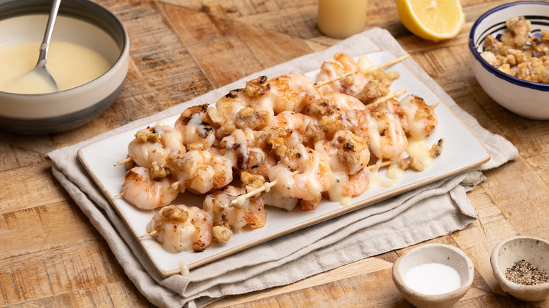 a plate of grilled honey walnut shrimp next to seasoning