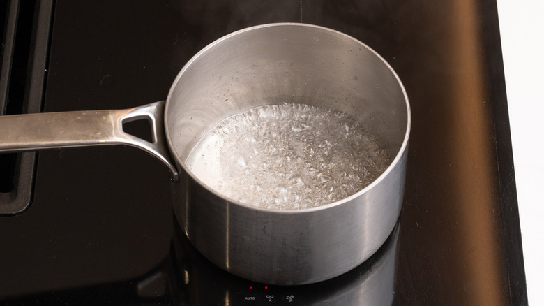 boiling sugar and water in a saucepan on the stove