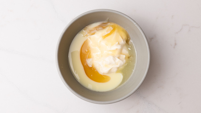 mayonnaise, condensed milk, honey, and lemon juice in a bowl
