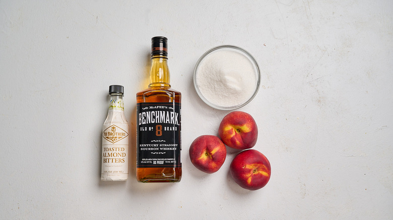 Grilled peach old fashioned ingredients on a table