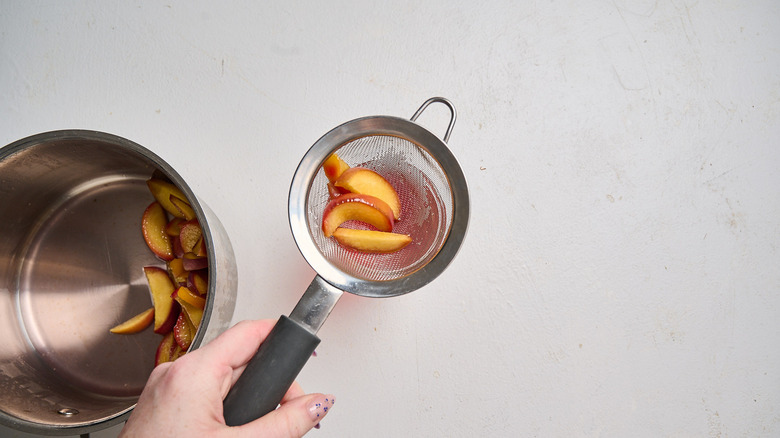 straining peach syrup into a jar