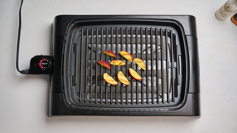 grilling peach slices on a grill