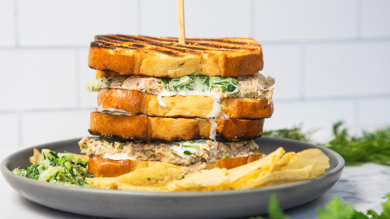 Two grilled salmon salad sandwiches one on top of the other.