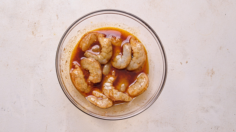 tossing shrimp in marinade