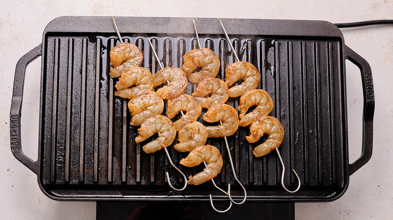shrimp skewers cooking on grill