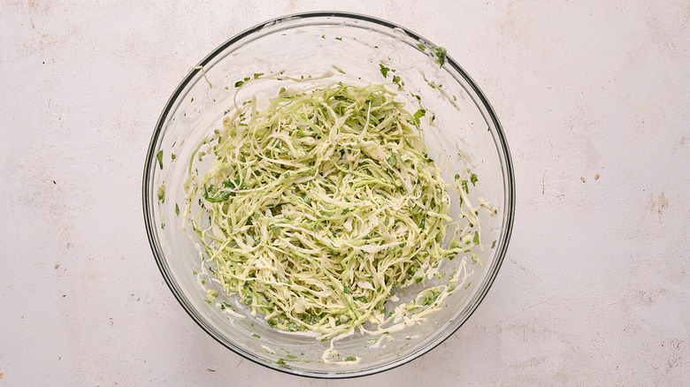 tossing cabbage slaw in a bowl