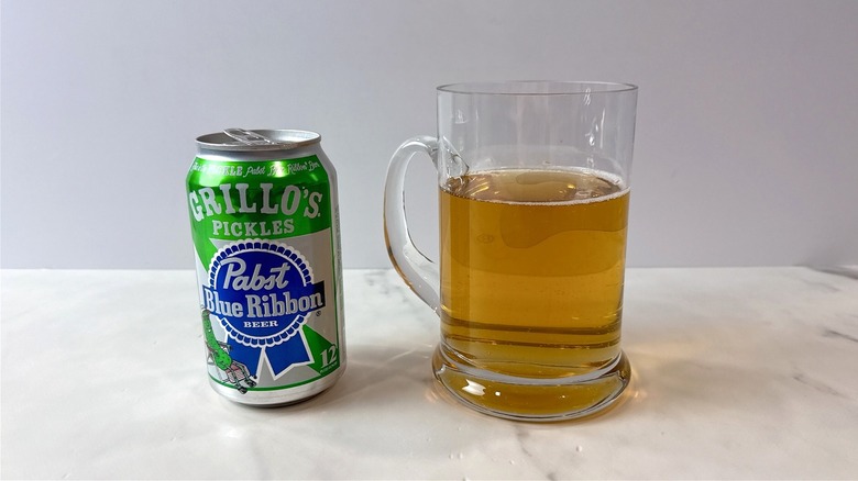 one can of Pabst blue ribbon Grillo's pickle beer and a mug of beer