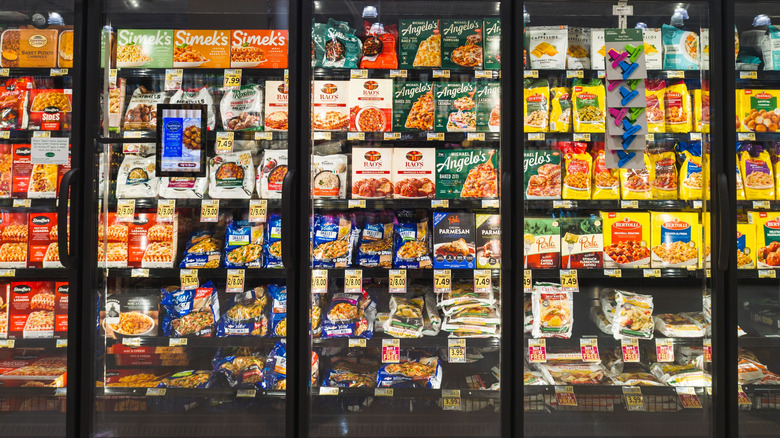 Frozen meals populate the freezer aisle of a grocery store