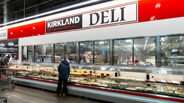 A customer looks over prepared foods at the Costco deli counter