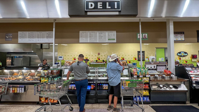 Customers wait by the deli counter at Publix