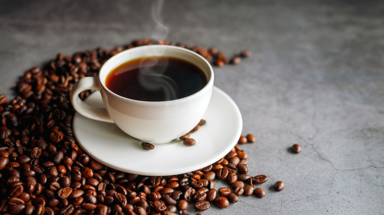 Coffee cup and coffee beans on gray background