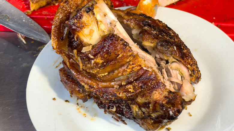 A roasted pork knuckle on a white plate