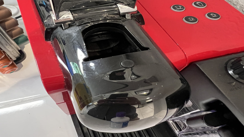 A Nespresso machine is shown with the top open.
