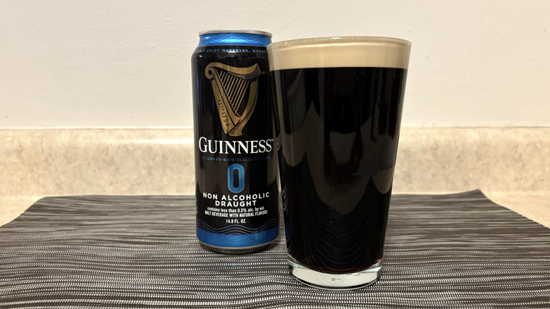 Guinness 0 in pint glass and can on bar mat