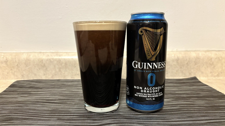 Guinness 0 in pint glass and can on bar mat