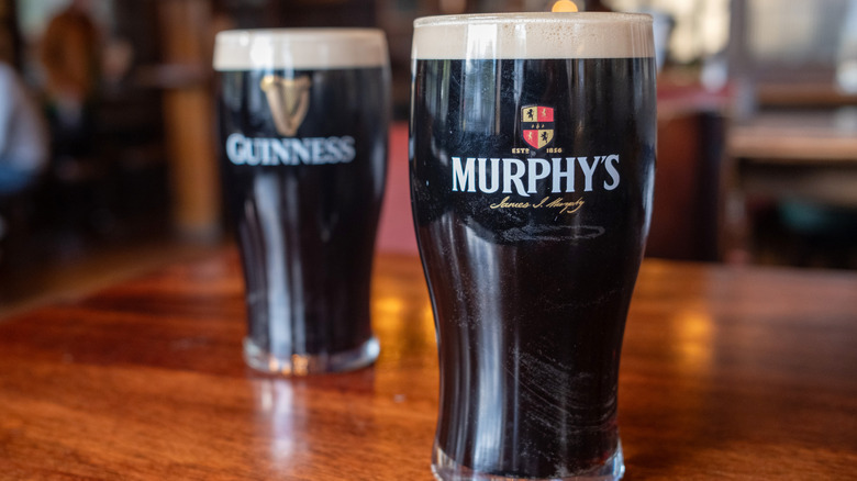 Murphy's stout on a wooden table, Guinness blurred in the background