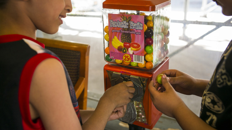 Gumball machine inside of a store with two children