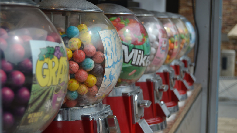 Row of dilapidated gumball machines at the front of a grocery store