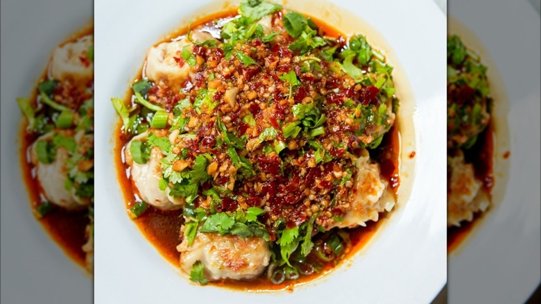 closeup of chili dumplings in white bowl, mirrored image