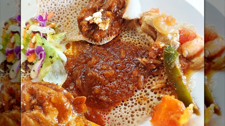 Injera with sauces and vegetables close up, mirrored image