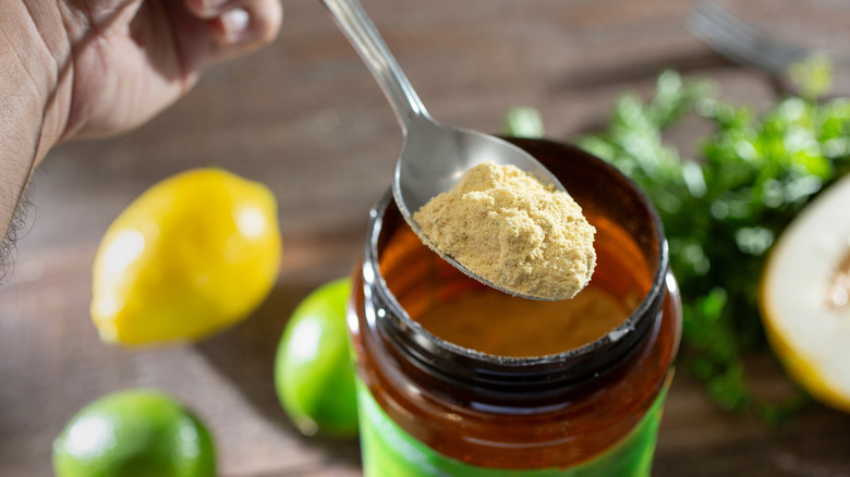 Spoon of chicken powder over container