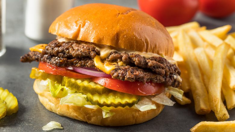 Burger with lettuce, onions, tomatoes, and pickles