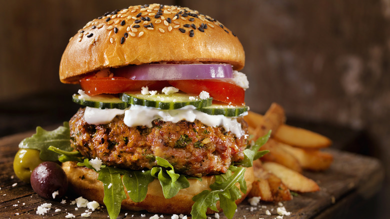 Lamb burger with olives, cucumbers, and tomatoes