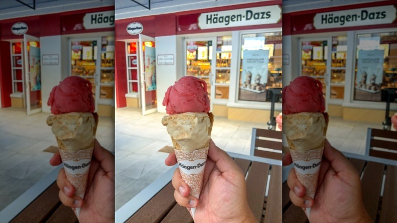 Hand holding an ice cream cone topped with two scoops of Häagen-Dazs