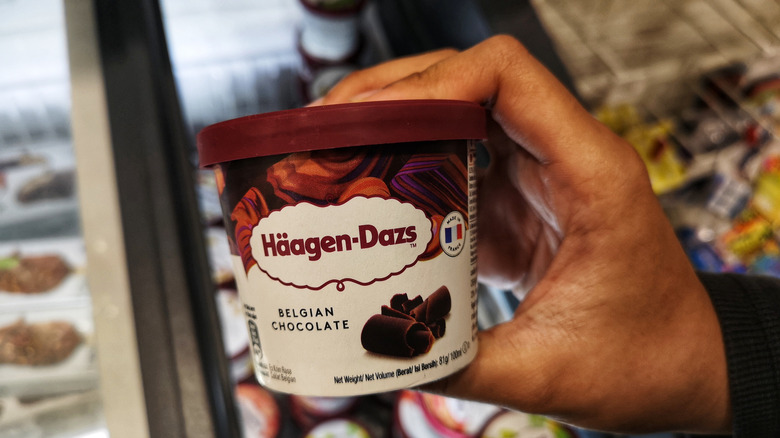 hand holding a piiiiint of Haagen Dazs Belgian chocolate ice cream