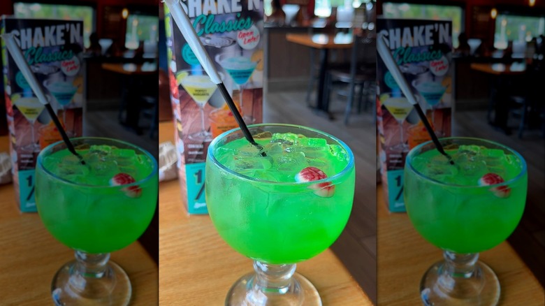 A glass of Tipsy Zombie sits on a table in front of the Applebee's special Halloween menu