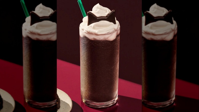 Starbucks Black Cat Frappucino and a Venti Black Night Cookie sit on a purple-colored counter