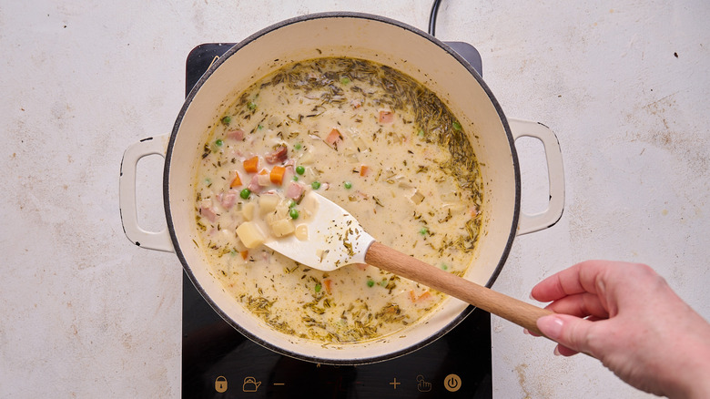 stirring potatoes and peas in a pot