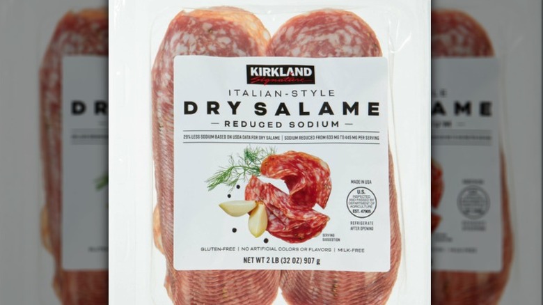 Dry salame with packaging on white background