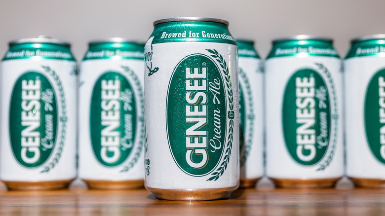 cans of Genesee Cream Ale lined up on a wooden table with one out in front