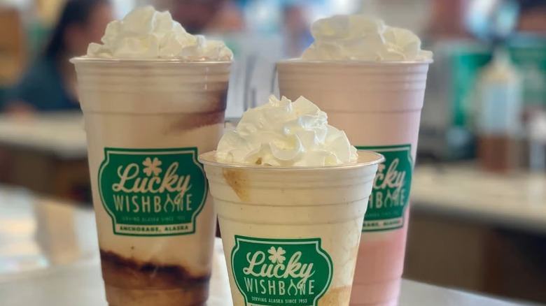 Three milkshakes of varying flavors topped with whipped cream