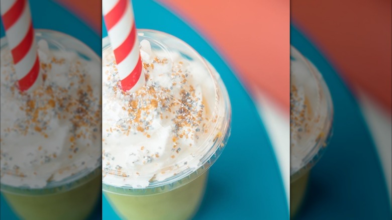 Matcha oat milk shake in clear plastic cup with straw sticking out top