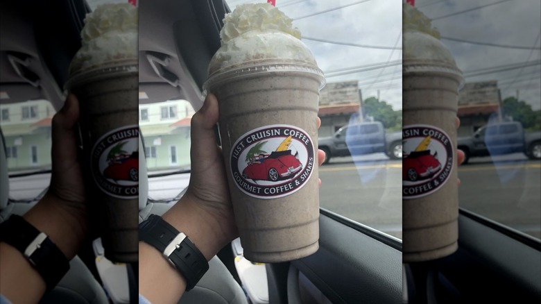 Hand holding Oreo milkshake in car