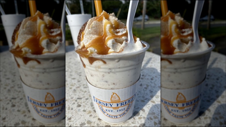 Milkshake topped with caramel sauce on outdoor table