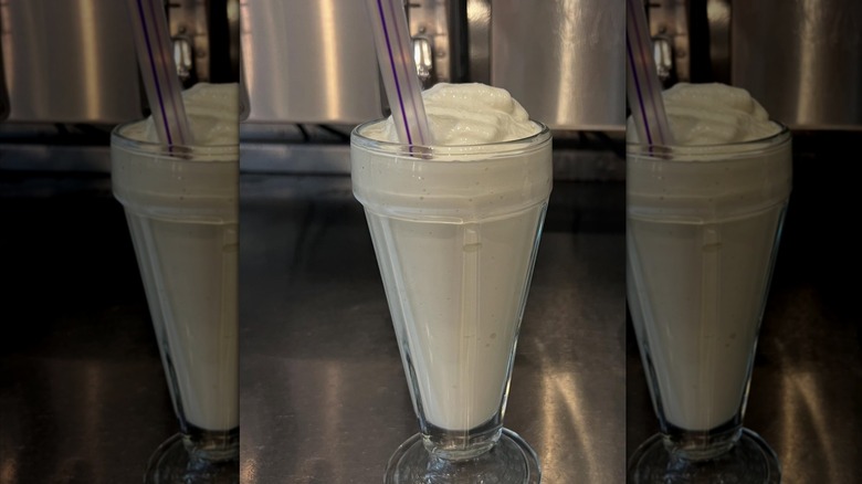Vanilla milkshake in glass with straw