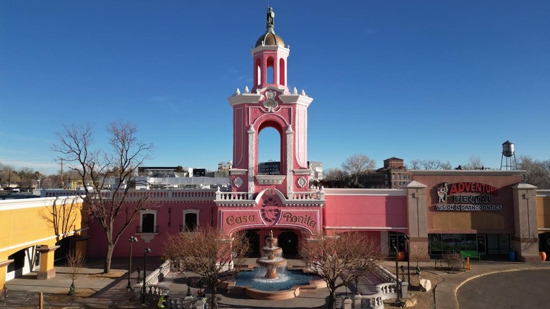 Casa Bonita's pink and white exterior with a fountain in the foreground