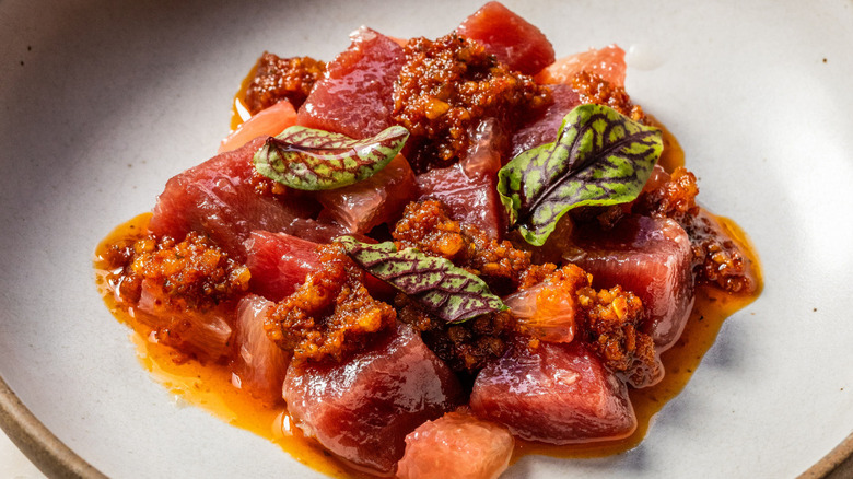 Plated bluefin tuna with grapefruit garnished with leaves and nuts