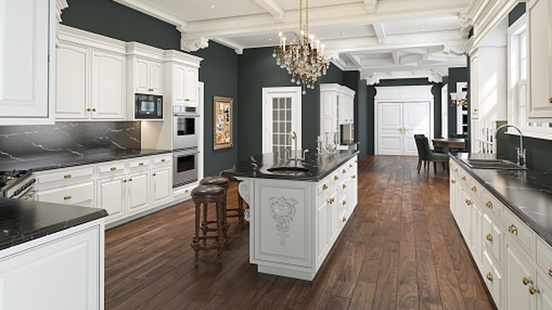A kitchen with white cabinets and hardwood floors