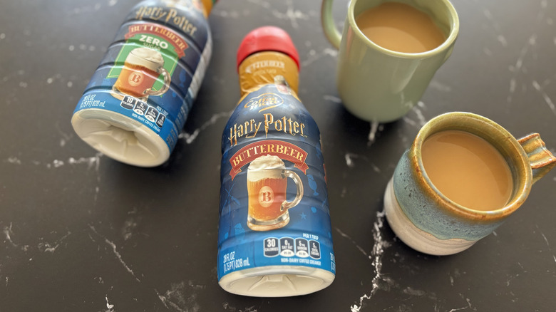 Harry Potter x Coffee mate Butterbeer Flavored Creamer bottles next to cups of coffee