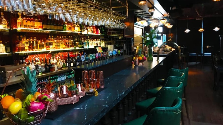 Interior of a chic bar with green leather seats and marble bar