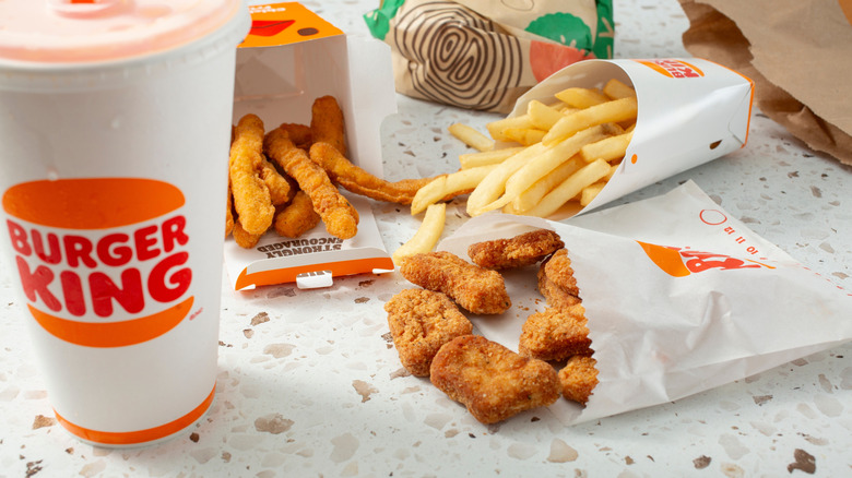 A table with Burger King menu items, including a soda, fries, chicken nuggets, and chicken fries.